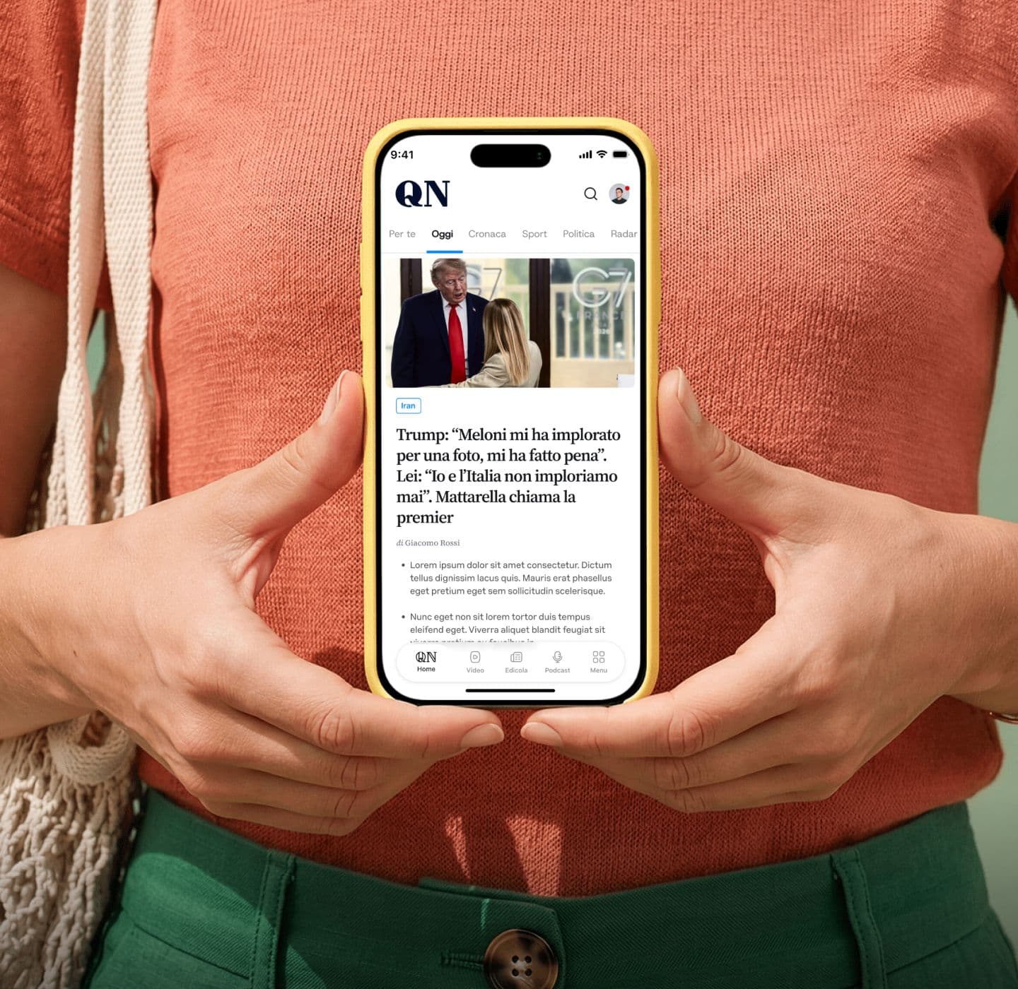 Una lettrice tiene in mano lo smartphone con l'app di QN aperta